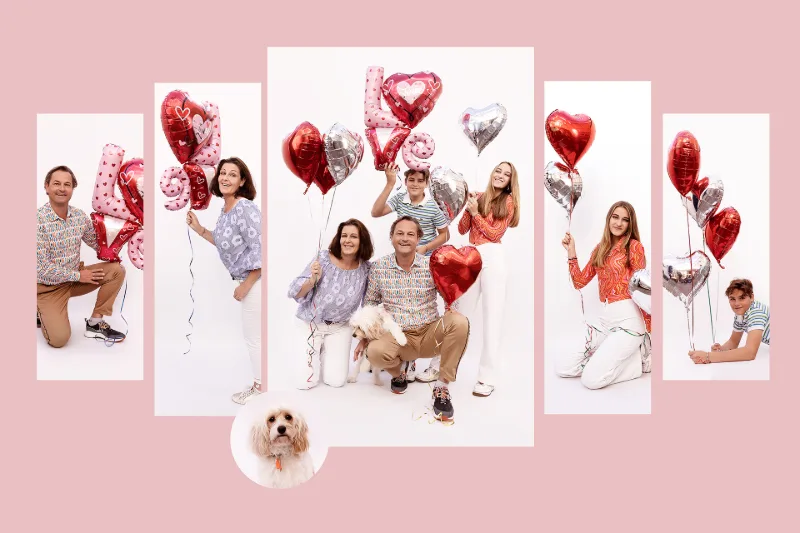 A family holding heart balloons that spell the word LOVE on a pink background, with the family dog